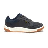 Zapatillas urbanas CAT modelo Apa Cush, color azul marino con detalles en naranja y suela de goma color caramelo. Capellada de cuero recubierta con PU, forro de malla interior hecho con residuos industriales 100% reciclados, plantilla acolchada de espuma, entresuela de EVA duradera y liviana y construcción Strobel.