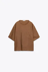 Blusa color marrón confeccionada en lino 100%, de corte holgado, cuello redondo, manga corta y bolsillo de parche en el pecho.