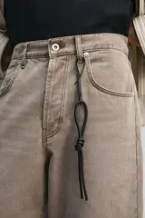 Llavero de cuero negro con detalle de nudo. El cordón presenta una ranura que permite ajustar el llavero como charm colgante en un bolso.
