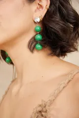 Aros largos colgantes con tres esferas verdes y pieza superior redonda plateada.