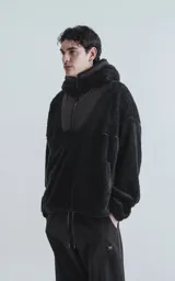Hoodie negro con capucha confeccionado en corderito y detalles de tela bomber en pecho, espalda, capucha y bolsillos.