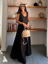 Vestido largo color beige claro, tipo solera, con escote redondo y tirantes anchos. El tejido parece ser crepé o un algodón ligero con textura, de corte amplio y fluido.