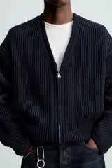 Cárdigan azul marino de punto con cremallera frontal, cuello en pico y manga larga.