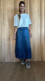 Pollera midi de jean celeste con corte en A y cintura elastizada.