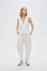 Pantalón blanco de poliéster, corte ancho, tiro alto y bolsillos laterales.