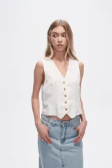 Chaleco blanco sin mangas con cuello en V y cierre frontal con botones.