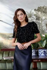 Top corto negro de terciopelo con escote bote, manga corta y bordado de lentejuelas.