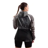 Campera rompevientos deportiva para mujer, color fucsia y violeta. La parte superior es de material traslúcido violeta, mientras que la parte inferior es de color fucsia sólido. Posee capucha, cierre frontal plateado y elástico en la cintura y puños.
