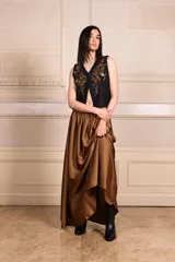 Chaleco blanco con bordados de hilo y canutillos, escote en V y cierre frontal con botones.