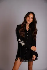 Camisa celeste de corte clásico, con botones frontales y bordados florales en las mangas.