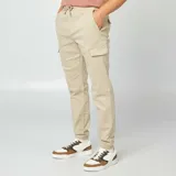 Pantalón cargo color beige, de corte slim fit, con cintura ajustable con cordón, bolsillos laterales con solapa y puños elásticos.