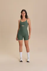 Jumpsuit corto deportivo color verde militar, con breteles finos ajustables, copas removibles, cintura en V y detalle cut-out en el pecho.