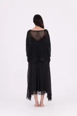 Sweater negro de punto abierto, con escote en V pronunciado y mangas tres cuartos. Presenta un calce amplio y holgado.