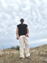 Pantalón de lino beige y crudo a rayas, de corte ancho y relajado.