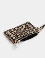Monedero de cuerina con estampado animal print, correa lateral y aplique de tachas decorativas. Cuenta con cierre superior y correa lateral.