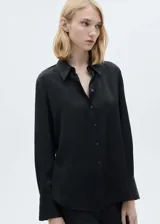 Camisa negra de manga larga con cuello clásico y cierre frontal con botones.