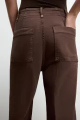 Jeans de tiro alto, pierna ancha y largo al tobillo, en denim celeste claro con efecto lavado. Presenta costura marcada en el centro de cada pierna y cierre frontal con cremallera y botón.