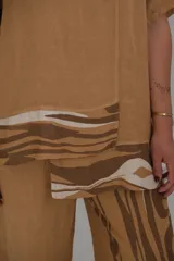 Blusa color camel con estampado de ondas en tonos marrones y blancos.