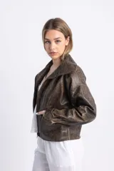 Chaqueta bomber de cuero marrón con efecto vintage, cierre frontal con cremallera, cuello alto y mangas largas.