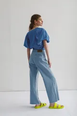 Blusa de escote pico, manga corta con volados en la parte delantera, fabricada en un tejido liviano y fresco.
