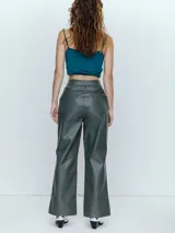 Pantalón de cuero verde oscuro, de corte recto y tiro alto.