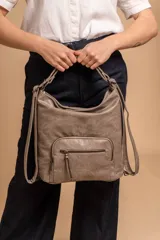 Cartera mochila color tostado, símil cuero, con compartimiento principal amplio y bolsillos frontales con cierre. Tiene correas ajustables para usar como mochila y asa superior para llevar al hombro.