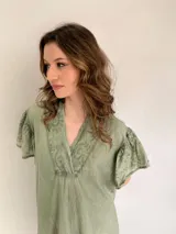 Vestido blanco de corte suelto, con escote en V y mangas cortas con detalles bordados.