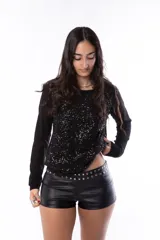 Microshort de cuerina negra tiro bajo, adornado con tachas plateadas.