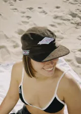 Gorra marrón de pana con visera, estilo 5 paneles y parche bordado en el frente.