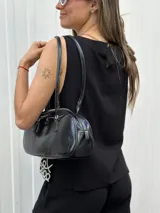 Blusa negra sin mangas con bordado blanco en el ruedo.