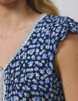 Conjunto de pijama marca René Rofé, compuesto por short y remera de tejido soft estampado con flores rosas sobre fondo blanco. Remera de escote en V con aplique de puntilla, botones y detalle plisado. Short con cintura elastizada.