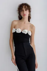 Top strapless negro con apliques de rosas blancas en el borde superior.