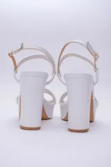 Sandalias negras de cuero con plataforma y tacón bloque alto. Tiras finas en el empeine y tobillo con hebilla dorada.