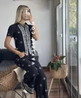 Conjunto de camisa de manga corta con cuello y pantalón largo de corte palazzo, ambos con estampado geométrico en blanco y negro.