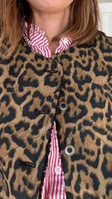 Chaleco reversible con un lado de corderito negro y otro de tussor con estampado animal print.