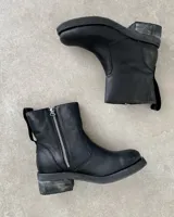 Botín marrón de cuero vacuno, con caña media, cierre lateral y suela de goma.