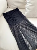 Maxi falda de encaje negro con cintura elastizada y abertura lateral.