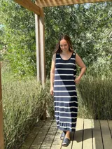 Vestido largo tejido a rayas horizontales azul marino y blancas, sin mangas, con cuello redondo y tajos laterales.