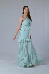 Conjunto de top y falda largo color celeste. El top es de breteles finos con detalle de encaje en el busto y la falda es de corte recto con volados en el ruedo.