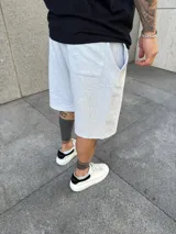 Bermuda deportiva gris de algodón, corte holgado con bolsillos laterales.