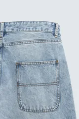 Pantalón de denim de algodón, color celeste claro lavado, de corte relaxed fit con tiro alto, bolsillos frontales y bolsillos traseros de plastrón.