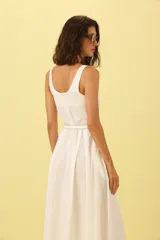 Vestido blanco midi con escote cuadrado, sin mangas y cinturón fino con hebilla dorada.