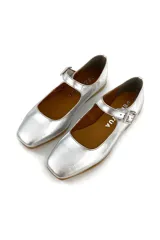 Zapato tipo Mary Jane plateado, 100% de cuero, con capellada, forro y plantilla de cuero. Ajuste con hebilla.