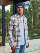 Sobrecamisa de manga larga a cuadros color beige y marrón, con cierre de botones y bolsillos en el pecho.