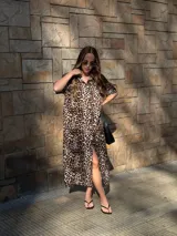 Camisola larga con estampado de leopardo, cuello camisero y manga corta. Presenta abertura frontal con botones y tajo lateral.