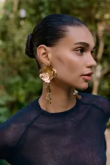 Aros colgantes metálicos dorados con forma de flor calada y hojas colgantes.