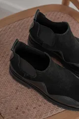 Botas Chelsea de cuero color marrón con paneles laterales elásticos negros y suela track de goma negra.