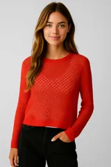Sweater de manga larga color rojo vibrante, tejido en punto calado con patrón de rombos. Presenta cuello redondo y puños y ruedo en punto liso.