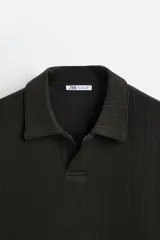 Polo azul marino de manga larga con cuello solapa, abertura frontal y acabado en rib.