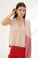 Chaleco de punto color rosa té con cuello en V y cierre frontal con botones.